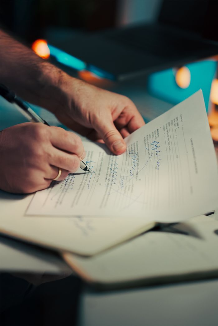 about-us Close-up of hands signing a business contract in an office environment. Ideal for legal and finance themes.