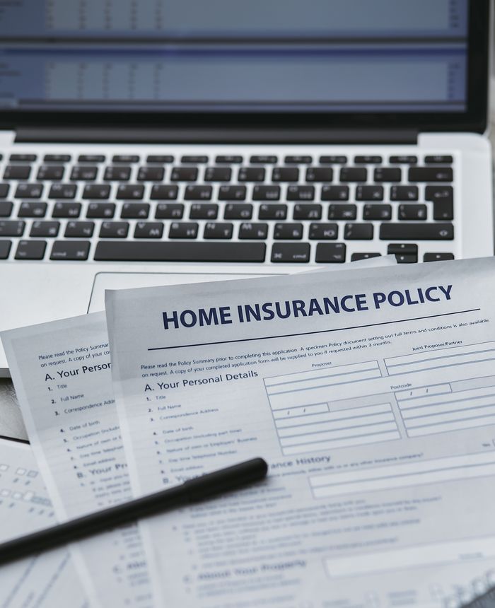 Mastering the First Impression: Your intriguing post title goes here Close-up of home insurance documents with a laptop, symbolizing modern paperwork processes.